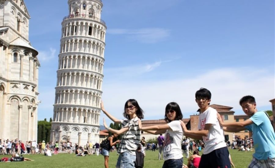 Chinese tourists pose with Leaning tower of Pisa