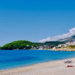 Beach in Vlore, Albania. Golden sands, blue sea and hills rising from the side of the beach. Image by Valter Zhara on Pexels