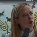 Meloni in Caivano, pictured against the mural wall of the school where she gave a press conference.