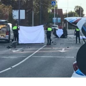 Road deaths in Sardinia - police shield the bodies of the dead at site of accident.