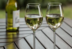 two wine glasses containing white wine and a bottle. Wine sector to receive support package