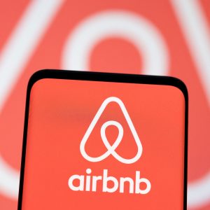 Airbnb logo on phone screen. Airbnb pays tax bill