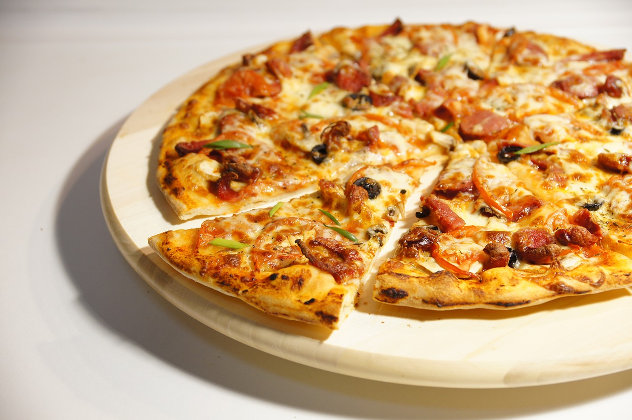 Pizza with a slice already cut Image by Artyom from Pixabay