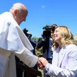 Was the G7 communiqué altered because Pope was in attendance? Image shows PM Giorgia Meloni greeting Pope Francis as he disembarks from helicopter.