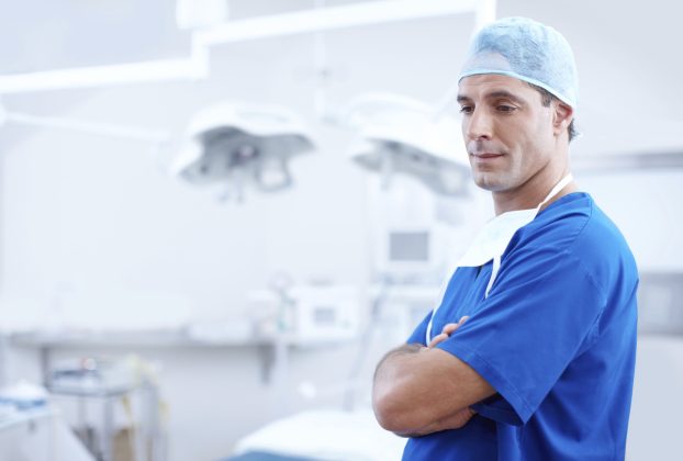 Jail time increased for attacks on medical staff. Image shows Doctor in blue outfit. Public health spending in Italy lowest in G7