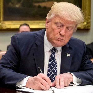 onald Trump signing an order for the Executive Team in the White House Credit: Andrew HarnikAP