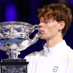 Sinner kisses the Australian open trophy having retained the title