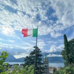 Bank Holidays in taly 2025. Image shows Italian flag flying over Lake Como. Credit: Photo by Tanya Lapko on Unsplash