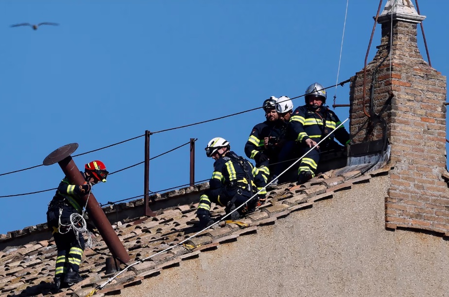 Firefighters install chimney which will signal the election of the new pope. Image credit: Mario Tama/Getty Images