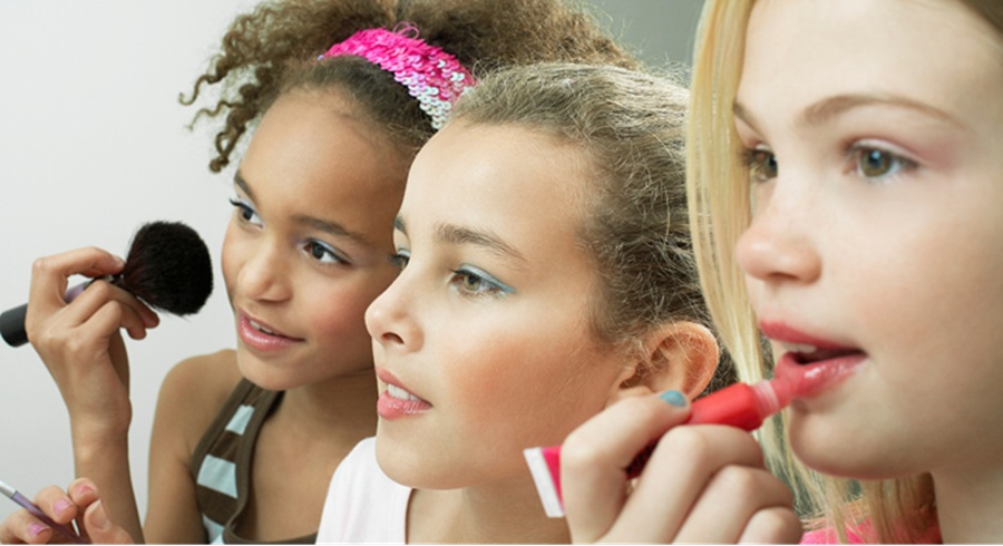 Italian authorities raid LVMH offices over marketing of Sephora and Benefit brands to young children. Image shows young girls using beauty products.