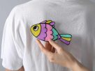 What's behind the tradition of the pesce d'aprile? Image shows someone sticking a colourful paper fish to the back of another.