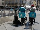 Glovo and Deliveroo investigated by Antitrust Authority. Image shows two Deliveroo riders refilling water bottles in Italy.