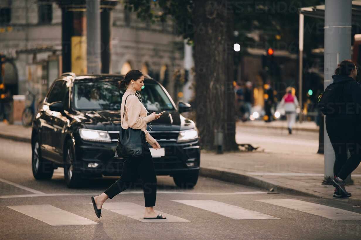 Pedestrians using phone whilst crossing the road Copyright: © by Westend61 / Maskot,