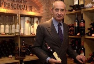 Vittorio Frescobaldi in a wine cellar holding a bottle of red wine